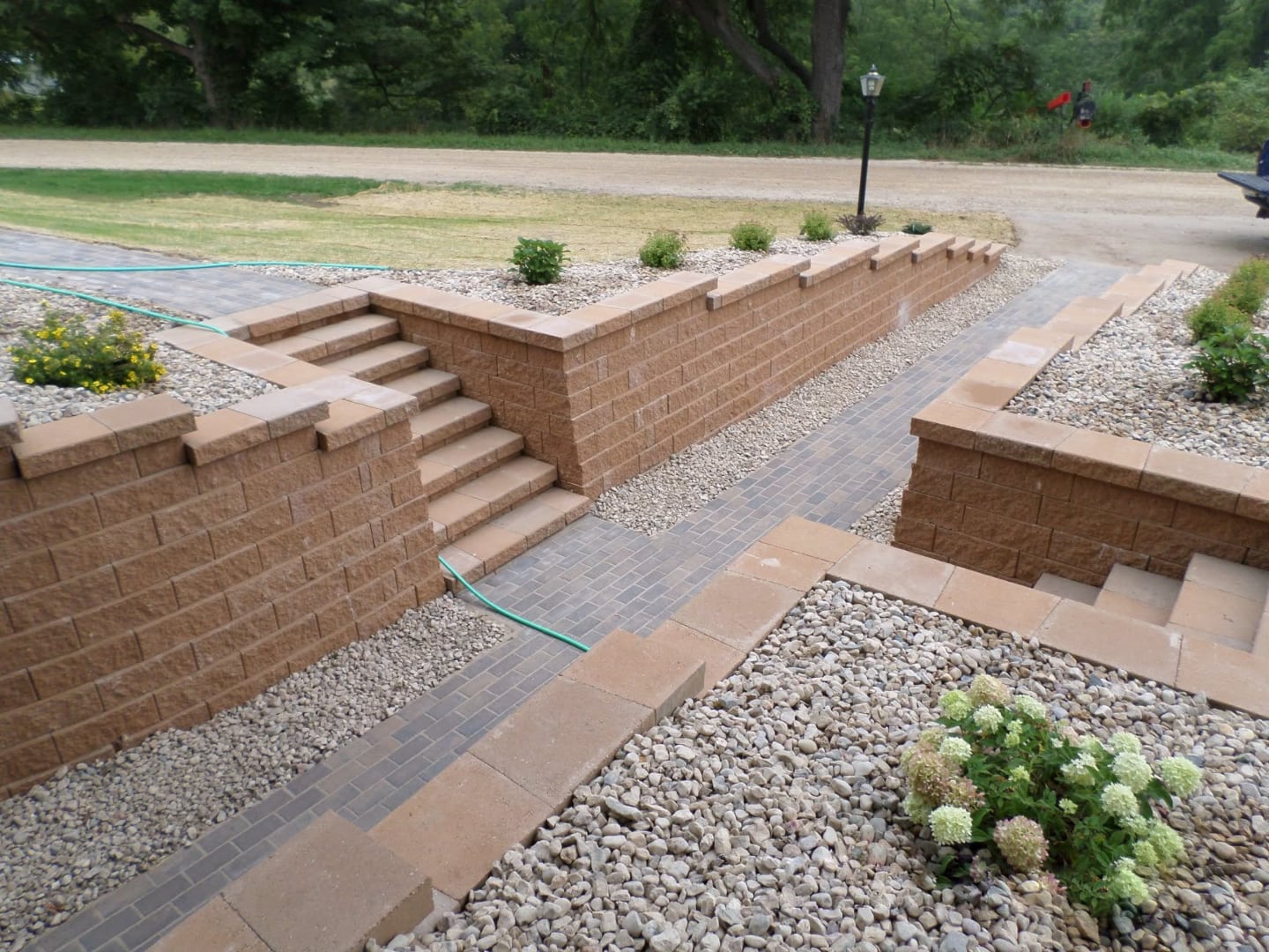 Tiered retaining wall system with paver walkway — great for sloped Lafayette County lots