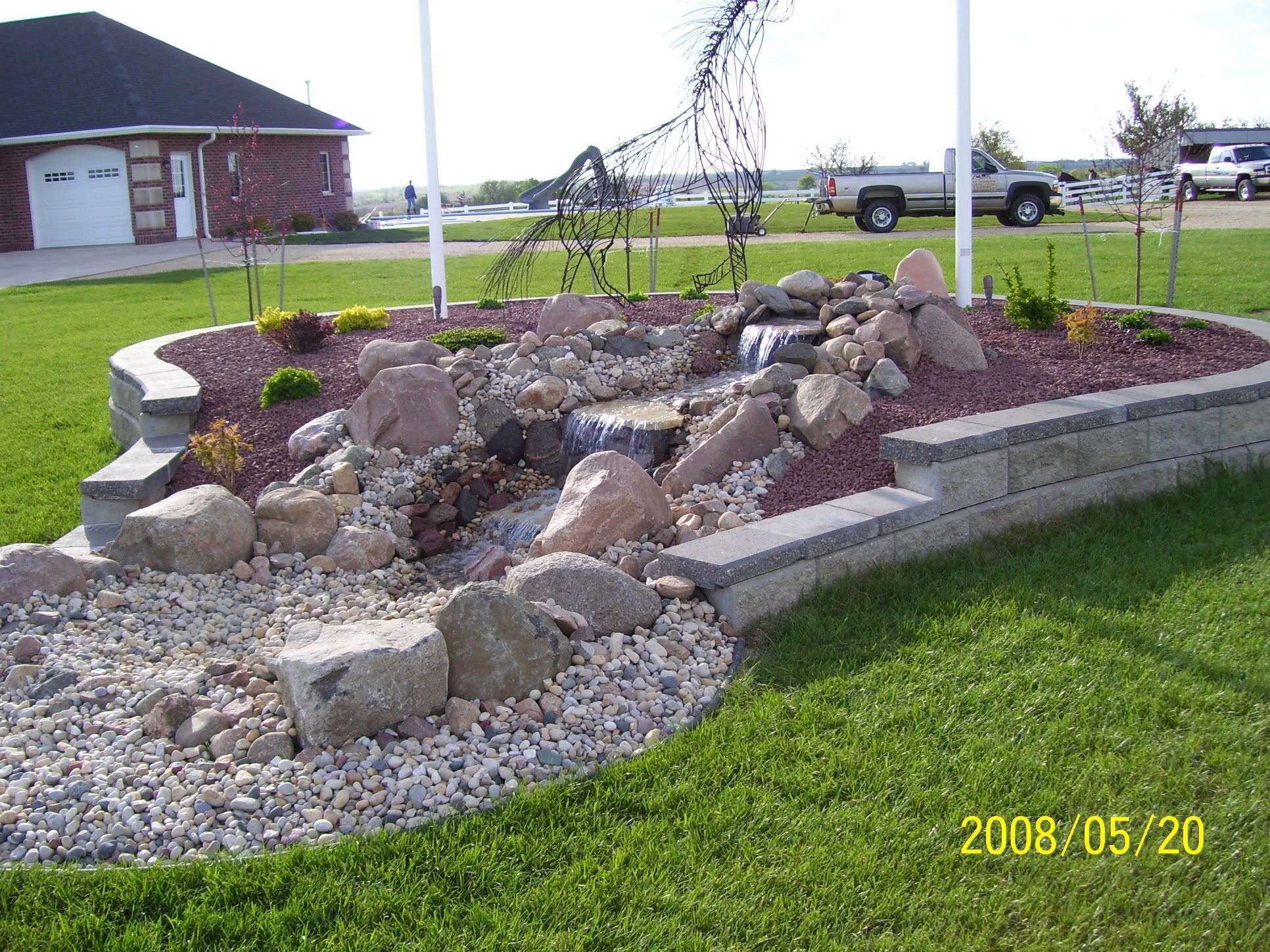Boulder waterfall and dry stream bed with rock garden and planting beds, southwest Wisconsin